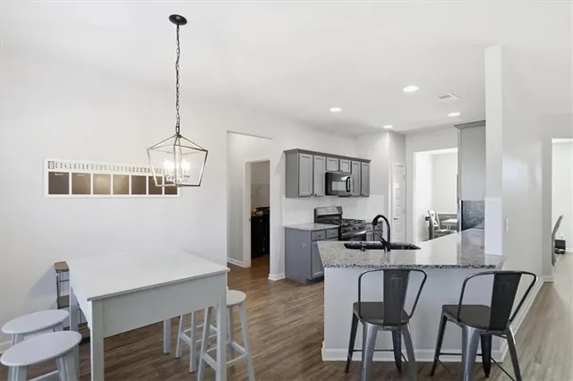 a kitchen with granite countertop a sink stove and refrigerator