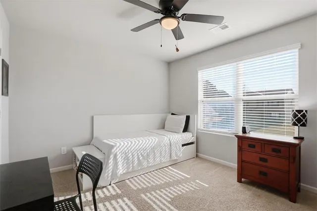 a spacious bedroom with a bed and a chandelier