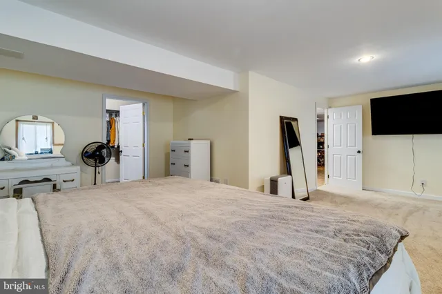 a spacious bedroom with a bed and a flat screen tv