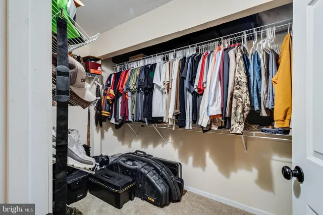 a view of walk in closet with clothes and shoes
