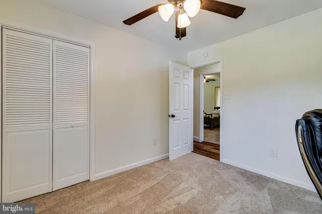 an empty room with chandelier fan