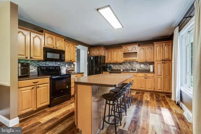 a kitchen with stainless steel appliances granite countertop a stove top oven a refrigerator a sink and a granite counter tops