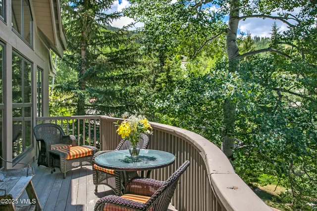 a view of a roof deck with table and chairs under an umbrella