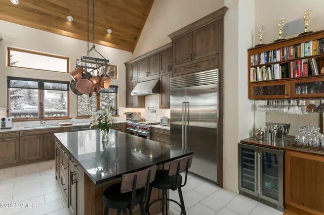 a kitchen with stainless steel appliances granite countertop a refrigerator a sink a stove and a refrigerator