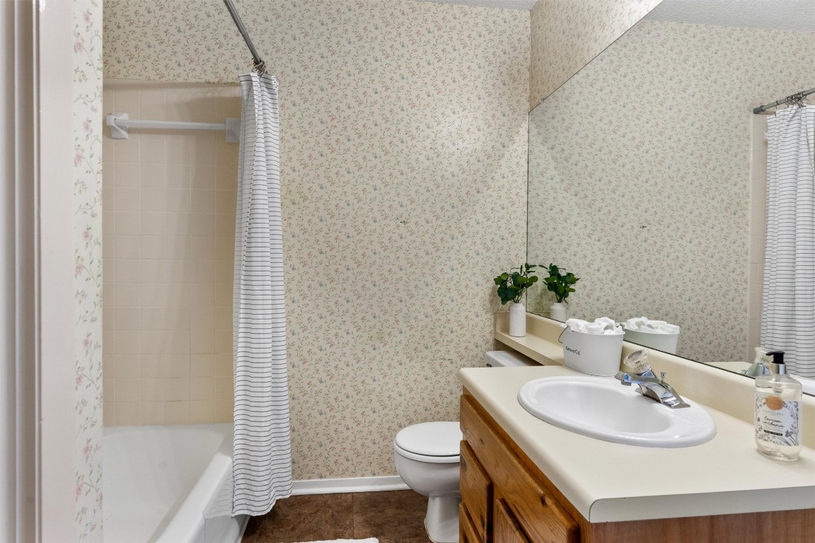 12314 Furrow Cove, Unit A Austin, TX 78753 - Photo 12 of 23 Bathroom with shower / bath combination with curtain, wallpapered walls, vanity, and dark tile patterned floors