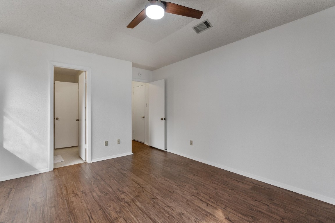 12314 Furrow Cove, Unit A Austin, TX 78753 - Photo 16 of 23 Unfurnished bedroom featuring ceiling fan and dark wood finished floors