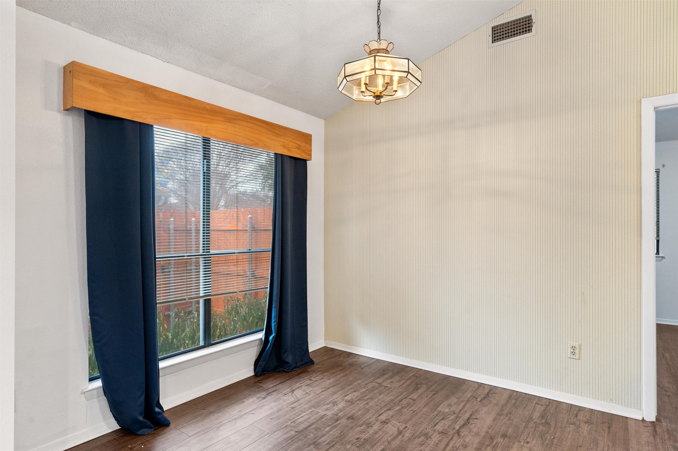 12314 Furrow Cove, Unit A Austin, TX 78753 - Photo 6 of 23 Empty room featuring dark wood-style floors, a chandelier, and vaulted ceiling