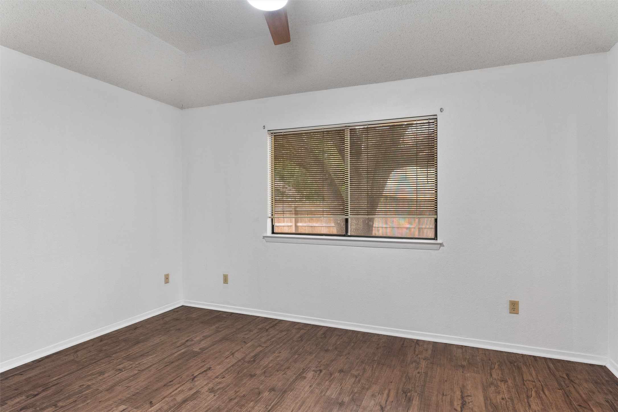 12314 Furrow Cove, Unit A Austin, TX 78753 - Photo 10 of 23 Unfurnished room featuring a textured ceiling, dark wood-style floors, and ceiling fan