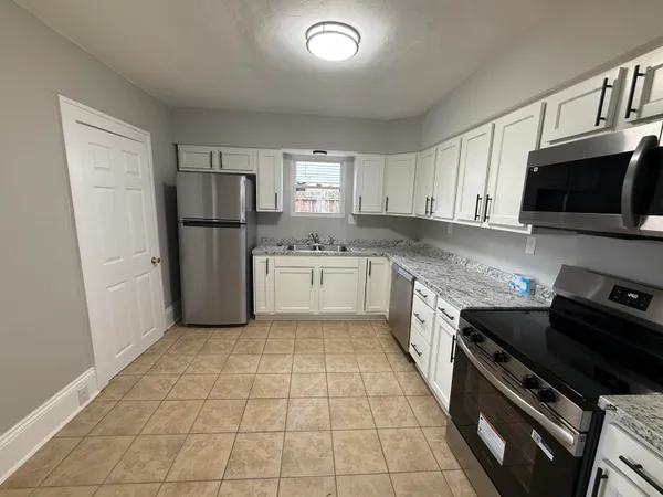 a kitchen with a refrigerator a stove top oven a sink dishwasher and a refrigerator