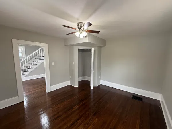 a view of empty room with wooden floor