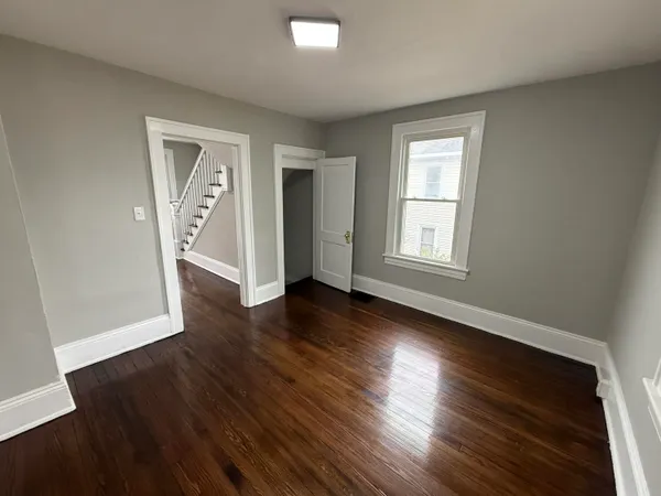 a view of a big room with wooden floor and windows