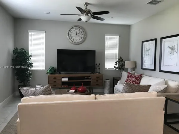 a living room with furniture a window and a potted plant