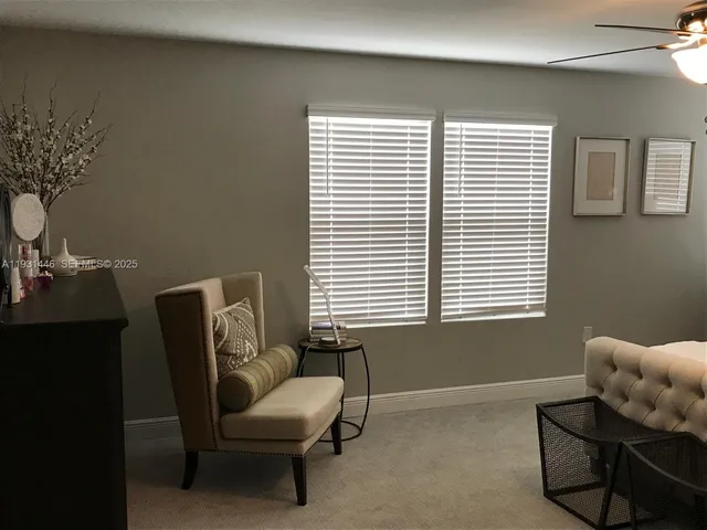 a living room with furniture and a floor to ceiling window