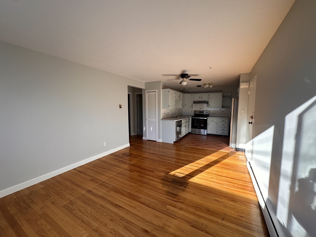 133 Warren Street, Unit 8 Watertown, MA 02472 - Photo 3 of 9 a view of kitchen and empty room with wooden floor