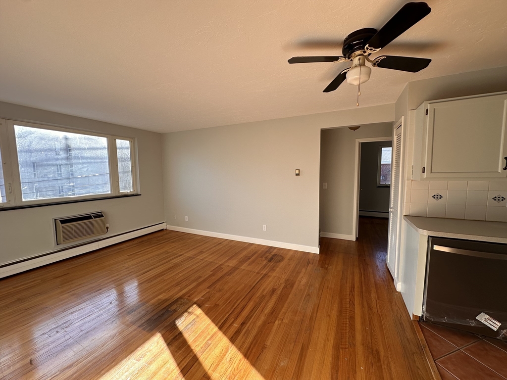 133 Warren Street, Unit 8 Watertown, MA 02472 - Photo 4 of 9 a view of empty room with wooden floor and fan