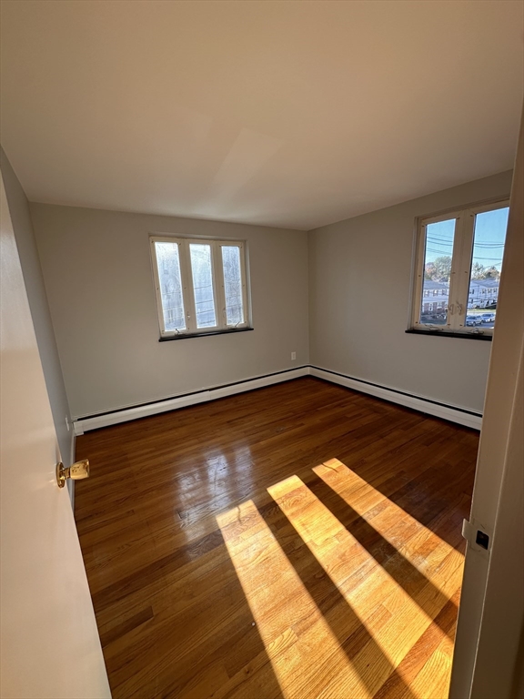 133 Warren Street, Unit 8 Watertown, MA 02472 - Photo 5 of 9 a view of an empty room with wooden floor and a window