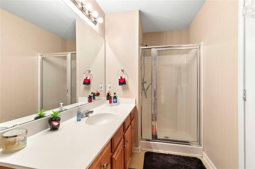 2555 Flat Shoals Road, Unit 5 Atlanta, GA 30349 - Photo 18 of 24 a bathroom with a sink vanity mirror and shower