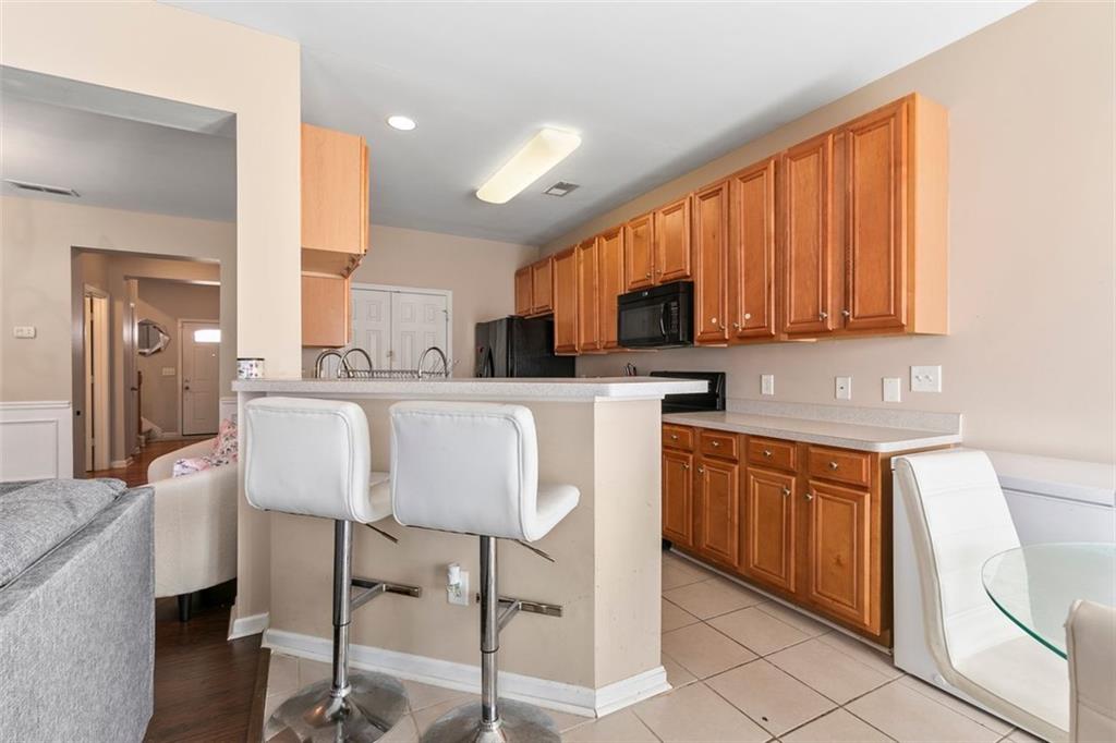2555 Flat Shoals Road, Unit 5 Atlanta, GA 30349 - Photo 6 of 24 a kitchen with stainless steel appliances granite countertop a table chairs sink refrigerator and cabinets