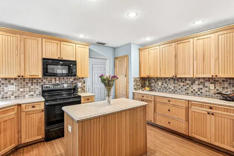 a kitchen with stainless steel appliances a stove sink microwave and cabinets