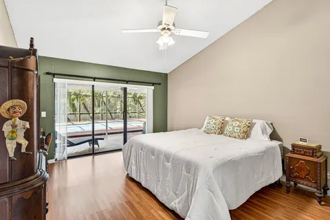 a bedroom with a large bed and a large window with wooden floor