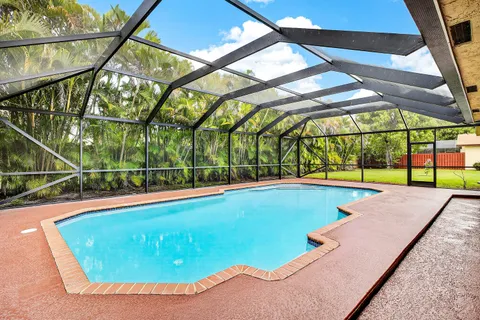 a view of a swimming pool with a yard and sitting area