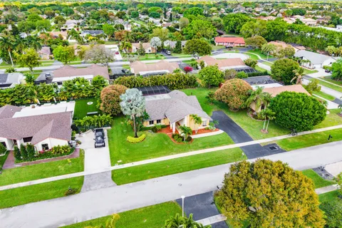 an aerial view of residential houses with outdoor space and street view