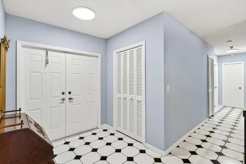 a view of a hallway with windows and chandelier