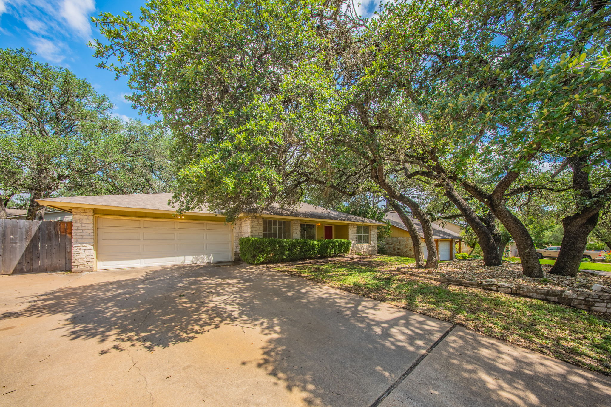 4504 Langtry Lane Austin, TX 78749 - Photo 3 of 24 Mature trees canopy this inviting residence, featuring a sturdy stone and siding exterior with an attached garage.