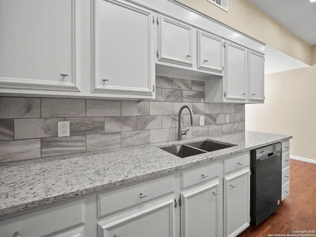 a kitchen with white cabinets and a sink