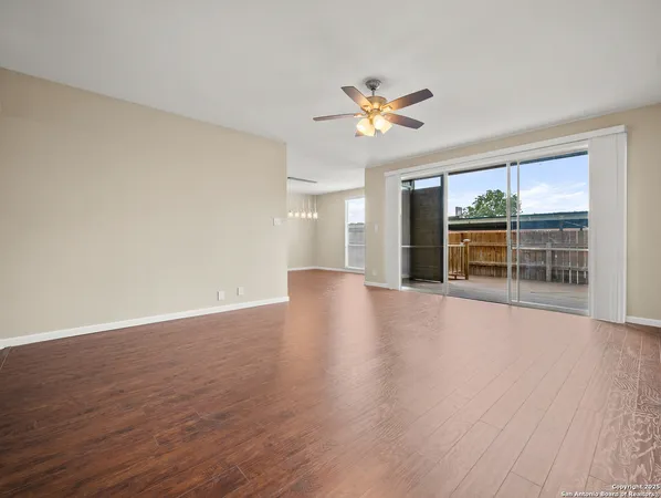 a view of a livingroom with wooden floor and fan