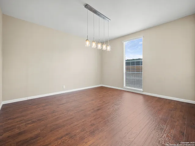 a view of a livingroom with wooden floor and a window