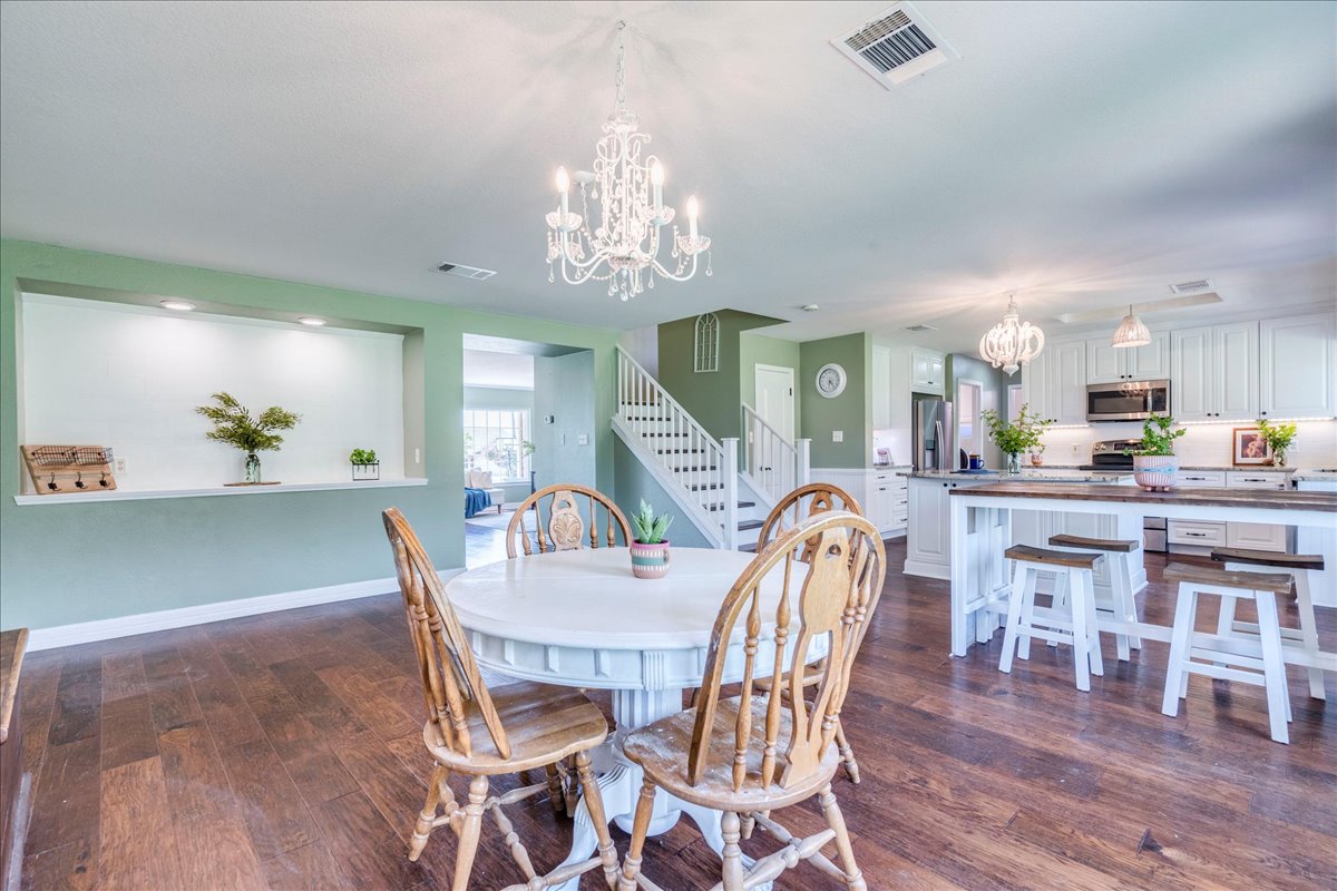 200 South Prairie Lane Georgetown, TX 78633 - Photo 11 of 28 a dining room with furniture a chandelier and wooden floor