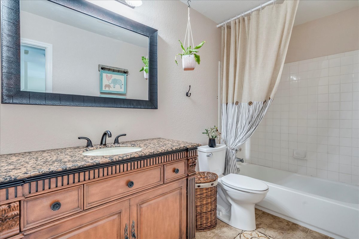 200 South Prairie Lane Georgetown, TX 78633 - Photo 24 of 28 a bathroom with a granite countertop toilet sink and mirror