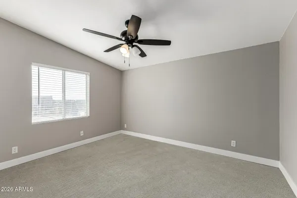a view of a big room with a ceiling fan and windows