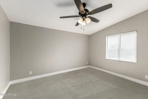 an empty room with a window and a fan