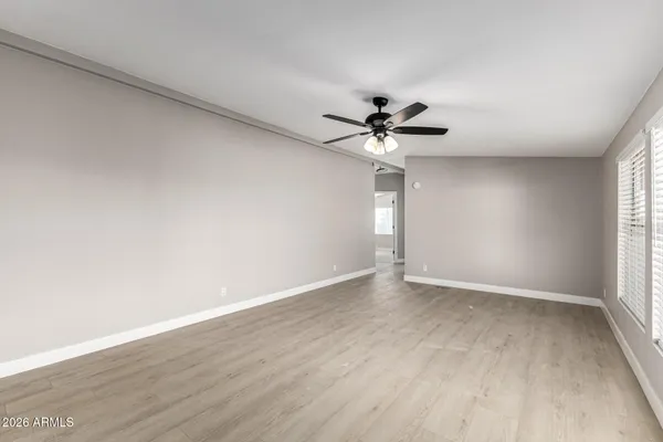 a view of an empty room with a window and a kitchen