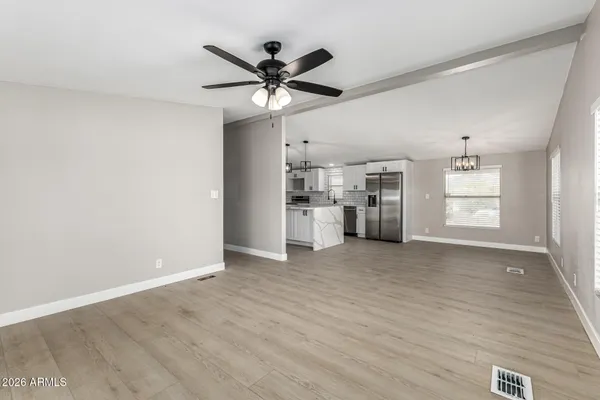 a view of a kitchen with a sink cabinet a ceiling fan and wooden floor