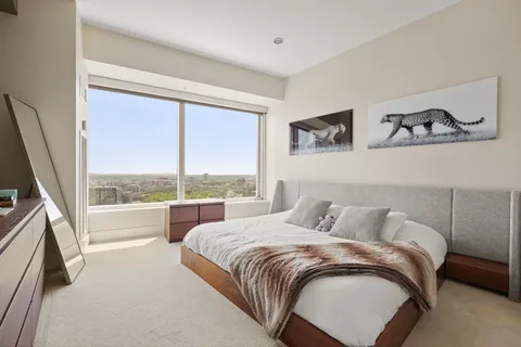 a bedroom with a bed and a large window