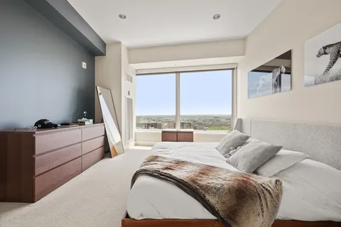 a bedroom with a bed and large window