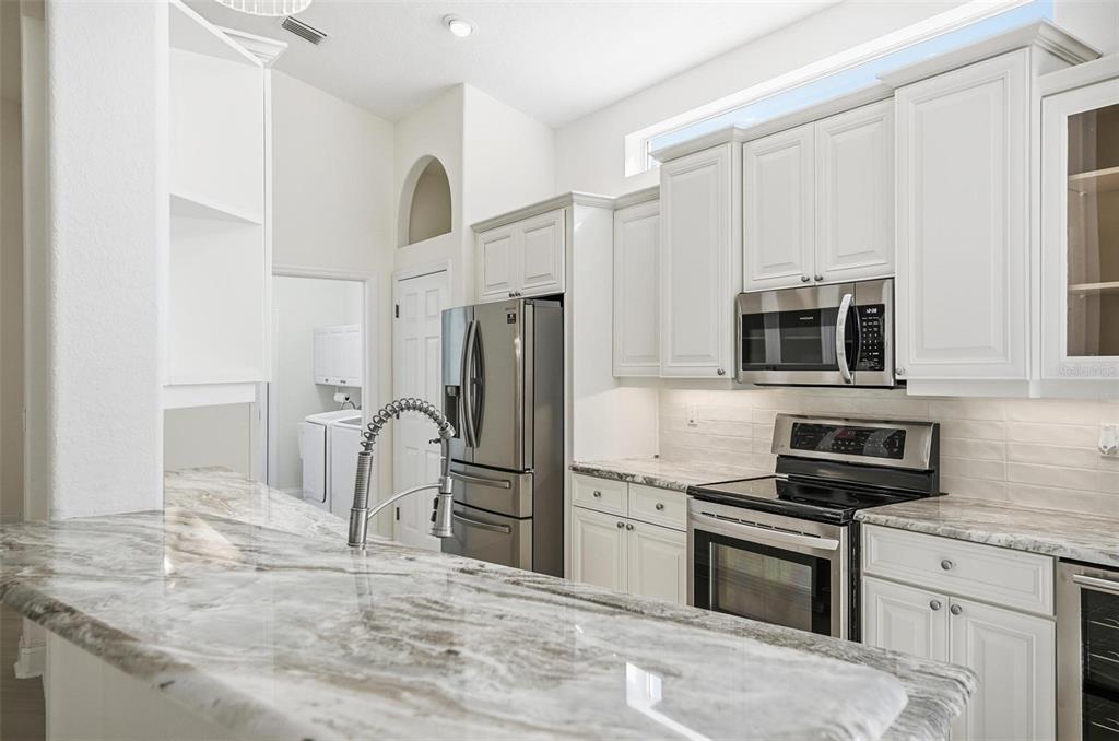 16 Village View Way Palm Coast, FL 32137 - Photo 14 of 89 a kitchen with stainless steel appliances granite countertop a stove refrigerator and microwave