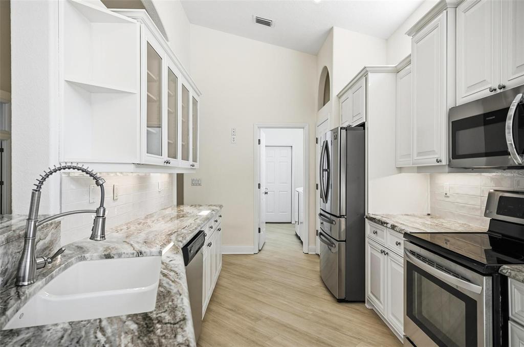 16 Village View Way Palm Coast, FL 32137 - Photo 17 of 89 a kitchen with stainless steel appliances granite countertop a sink stove and refrigerator