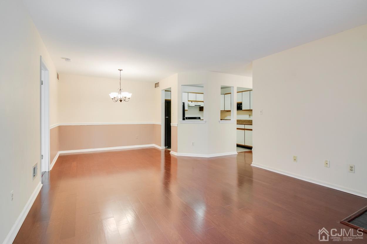 205 Raintree Court Helmetta, NJ 08828 - Photo 5 of 25 an empty room with wooden floor and windows