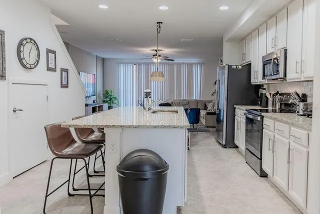 a kitchen with stainless steel appliances granite countertop a sink refrigerator and microwave