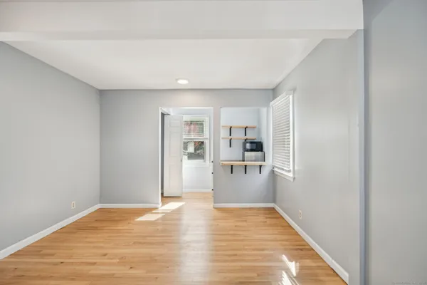a view of a room with wooden floor and a hallway