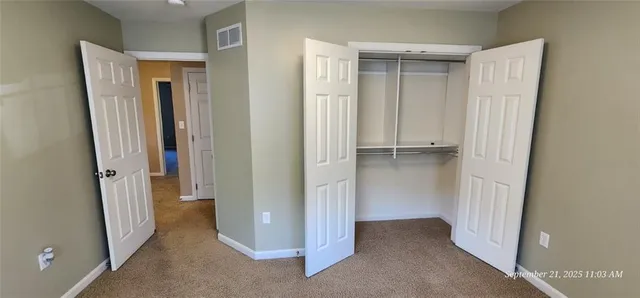 a view of empty room with a fireplace and windows