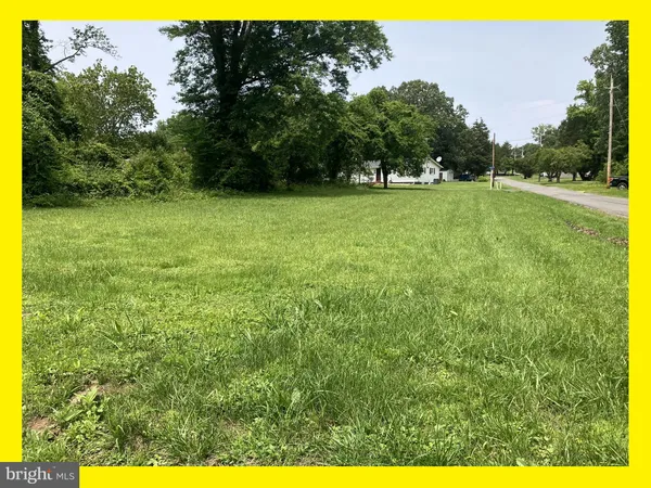 a view of a green field with trees in the background