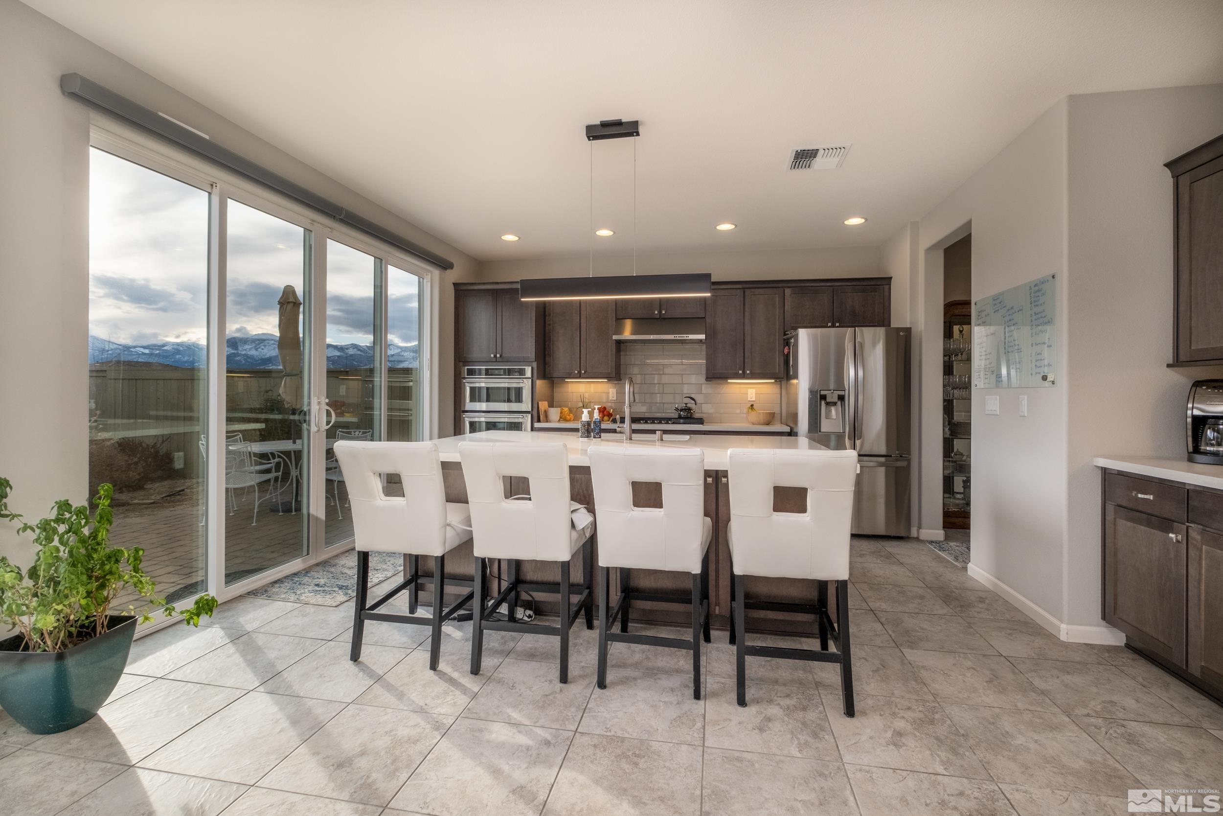 2960 Ethelinda Way Reno, NV 89521 - Photo 8 of 40 a dining area with stainless steel appliances kitchen island granite countertop a dining table chairs and granite counter tops