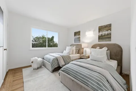 a bedroom with two beds and a window