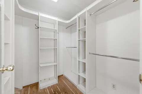 a view of walk in closet with empty racks
