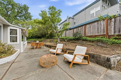 a backyard of a house with table and chairs